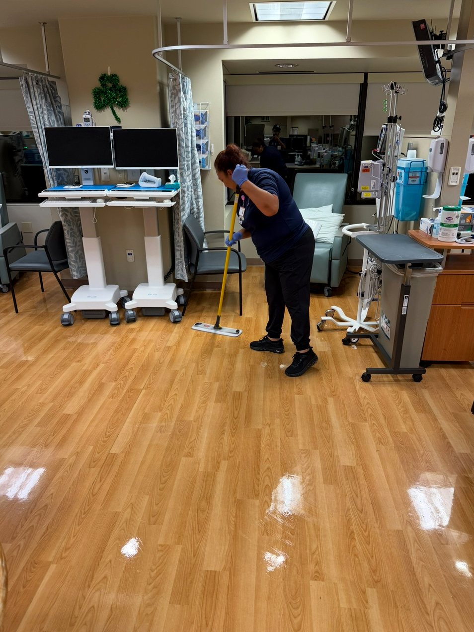 UFG environmental services technician completing floor care in a Sutter clinical room